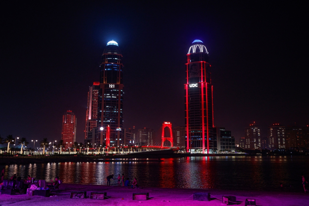 The illuminated Gewan Island Bridge and high-rise buildings are seen at the Pearl Island in Doha