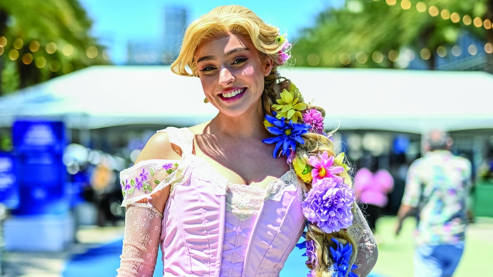 A visitor dressed as Rapunzel poses during the D23 Disney event.