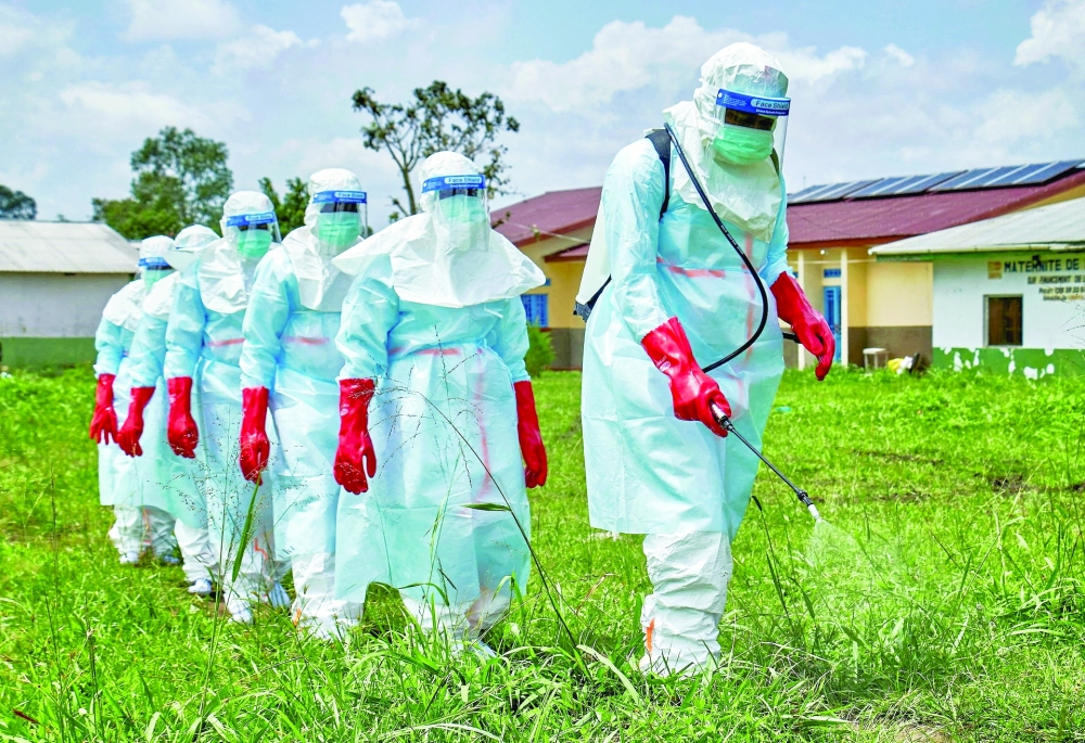 Red Cross workers walk in formation as they disinfect Rwampara General Hospital in Ituri province, DR Congo. — Reuters
