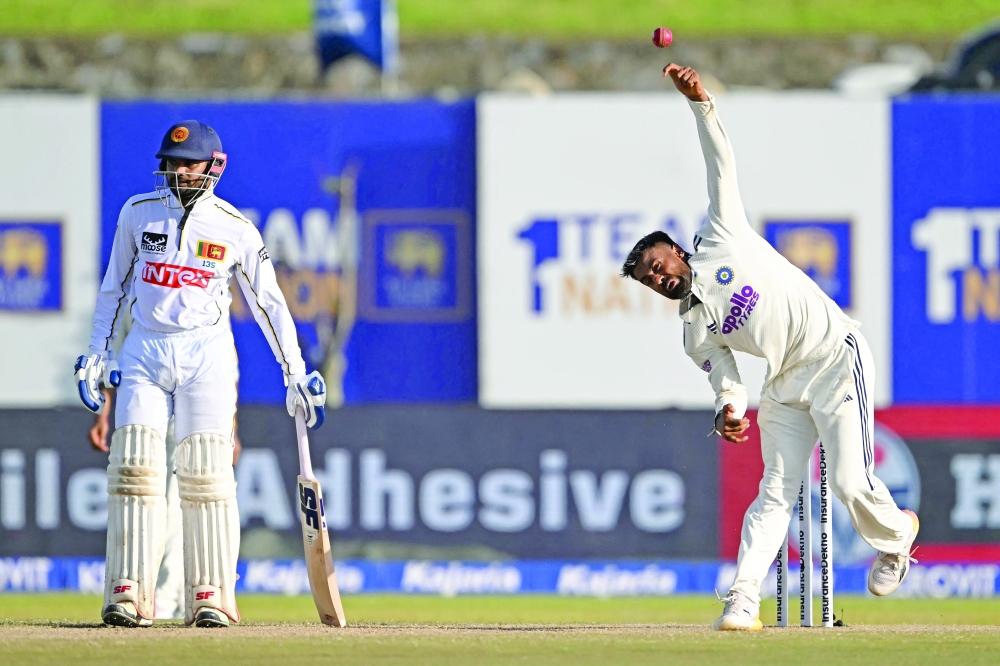 India's Manav Suthar (R) delivers a ball as Sri Lanka's captain Dhananjaya de Silva looks on during the fourth day of the first Test in Galle. — AFP
