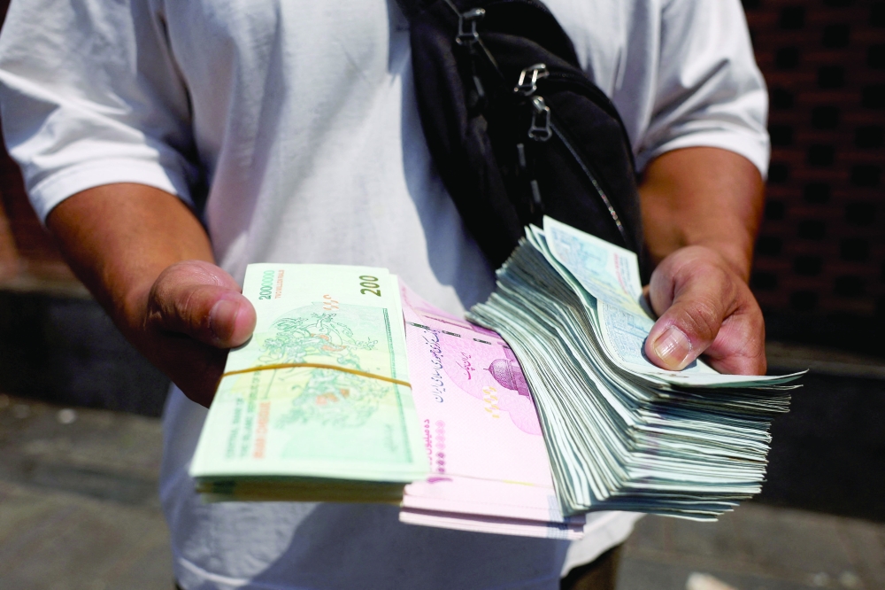 A currency dealer holds Iranian rials in the Grand Bazaar in Tehran, Iran, on Tuesday. - Reuters