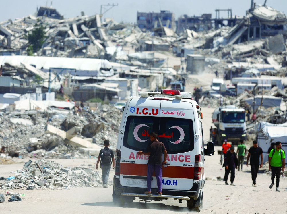 A person stands on the back of an ambulance at a site destroyed during the Israeli offensive, in Beit Lahiya, in the northern Gaza Strip, August 18, 2026. REUTERS/Mahmoud Issa     TPX IMAGES OF THE DAY     