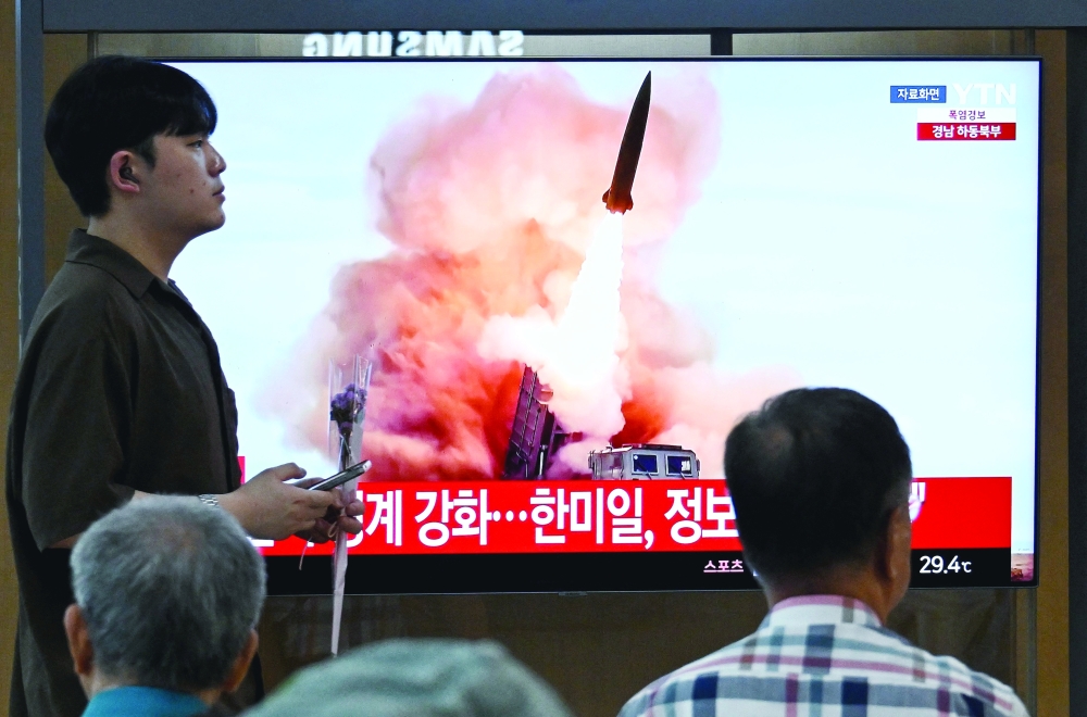 People watch a TV screen showing a news broadcast with file footage of a North Korean missile test, at a train station in Seoul. — AFP