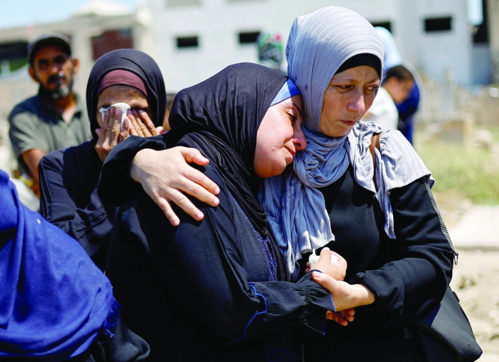 Palestinians attend the funeral of 50 people from three families killed during the war and whose bodies were retrieved from under the rubble recently, in Gaza City. — Reuters