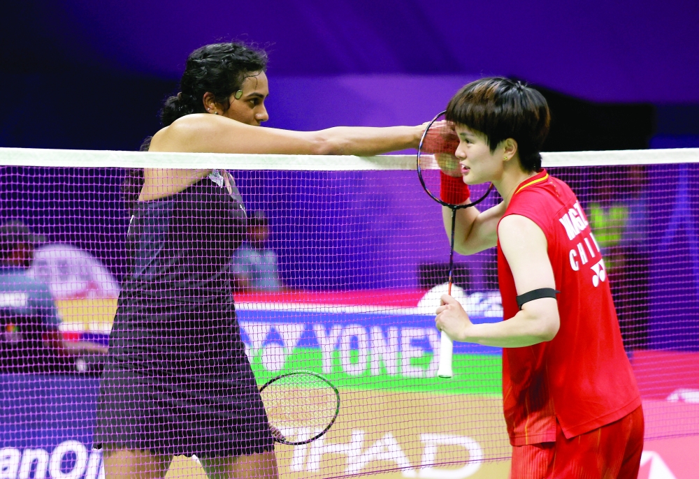 China's Zhi Yi Wang shakes hands with India's PV Sindhu after winning her round of 16 match in New Delhi. — Reuters
