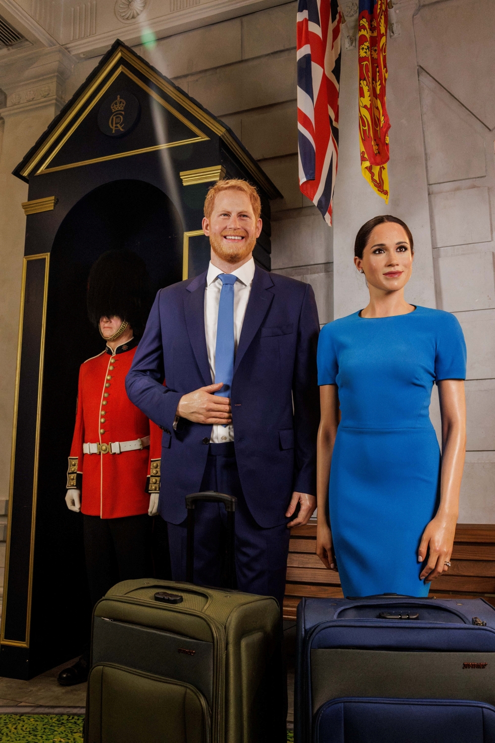 The waxworks of Britain's Prince Harry and his wife, Meghan, stand next to suitcases at the Madame Tussauds museum, in London,