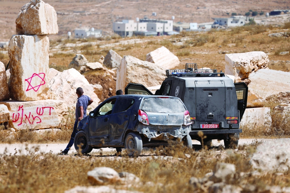 An Israeli police vehicle stands near the location where Israeli settlers set fire to stone quarry machinery near Hebron, in the Israeli-occupied West Bank. — Reuters