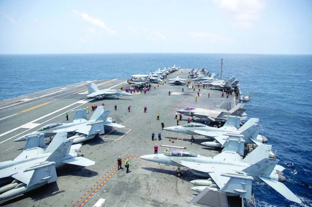 US Navy sailors work on the flight deck of the aircraft carrier USS George Washington as it transits the Arabian Sea to support US military operations in the war with Iran on Thursday. — Reuters