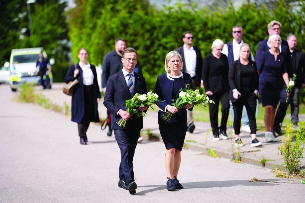 Swedish PM Ulf Kristersson and Social Democratic Party leader Magdalena Andersson visit a makeshift memorial outside a school in Fagersta, Sweden. — Reuters