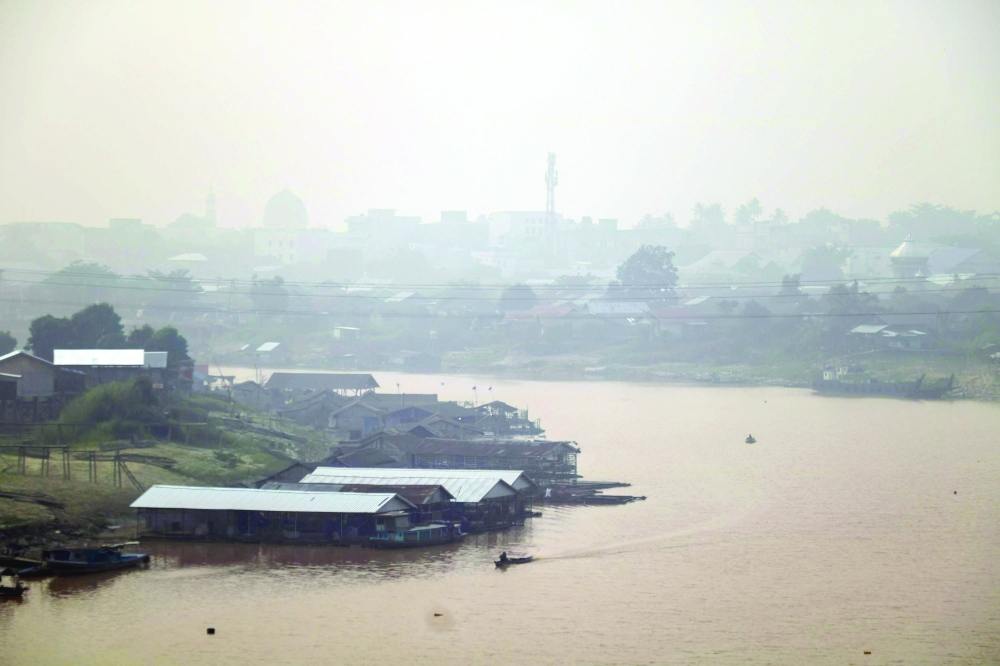 Haze blankets a riverside residential area along the Kahayan River in Palangkaraya. — AFP