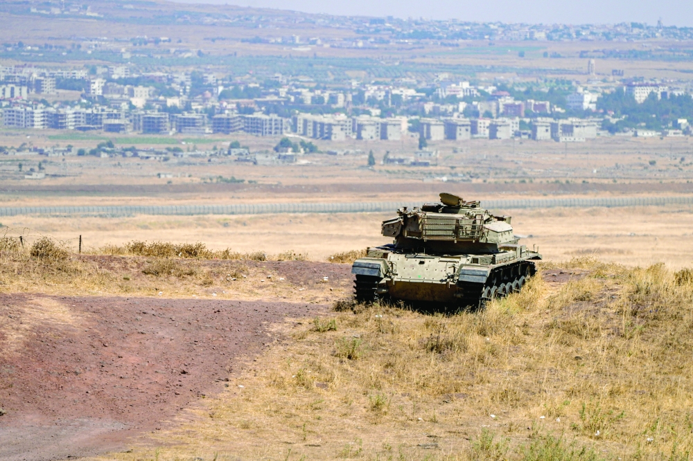 An Israeli tank stands in position near the ceasefire line between the Israeli-occupied Golan Heights and Syria. — Reuters