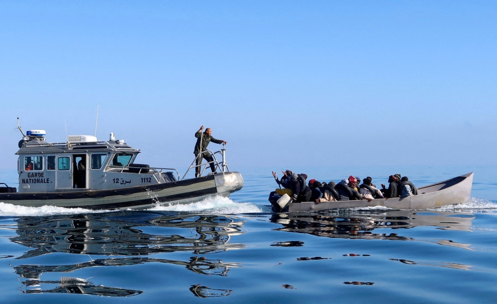 Tunisian coast guards try to stop migrants at sea during their attempt to cross to Italy. — Reuters file photo