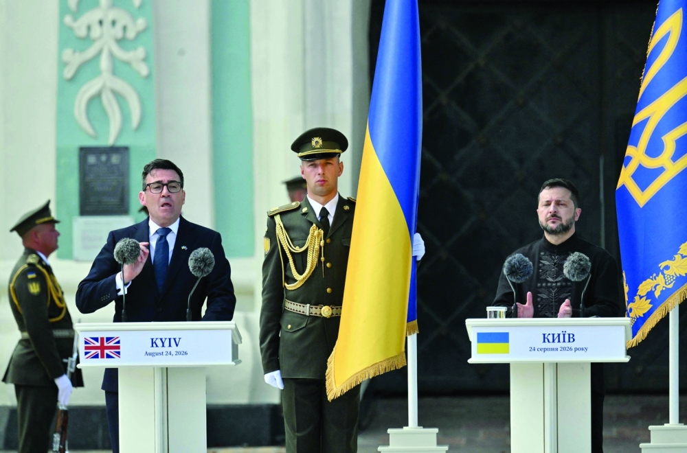 Britain's prime minister Andy Burnham (L) delivers a speech next to President Volodymyr Zelensky (R), outside St. Sofia cathedral in Kyiv. — AFP