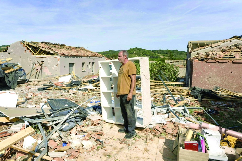 A man stands amongst the rubble of a damaged house following a tornado in Pomas, southwestern France. — AFP