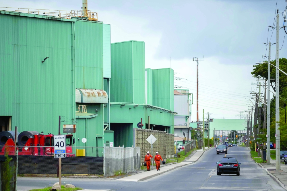 Workers walk during a shift change outside an ArcelorMittal Dofasco facility in Hamilton, Ontario. — AFP