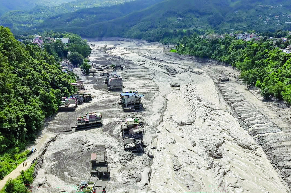 Houses lie partially submerged in muddy water along a riverside after flash floods at Trishuli Bazar in Nepal's Nuwakot district on Wednesday. — AFP