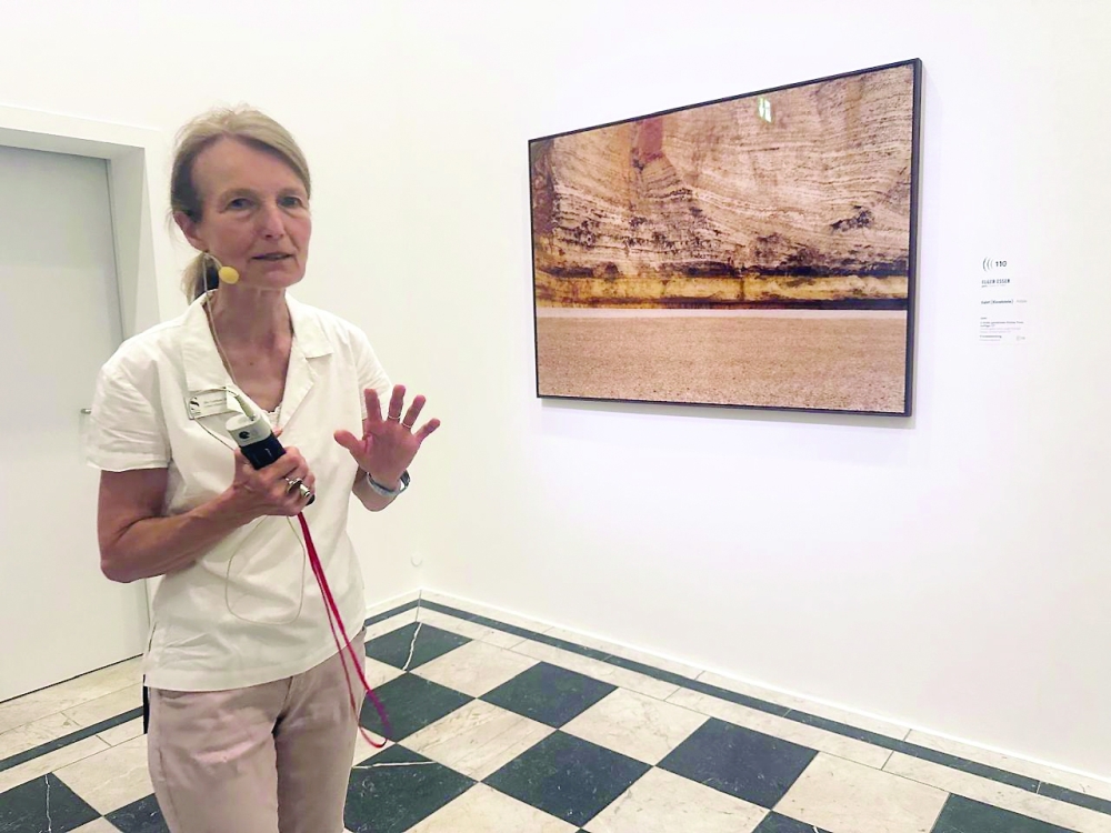 Dr Corinne Elsesser points out the cliffs in Elger Esser’s Étretat photograph at the Städel Museum’s 'Monet on the Normandy Coast' exhibition
