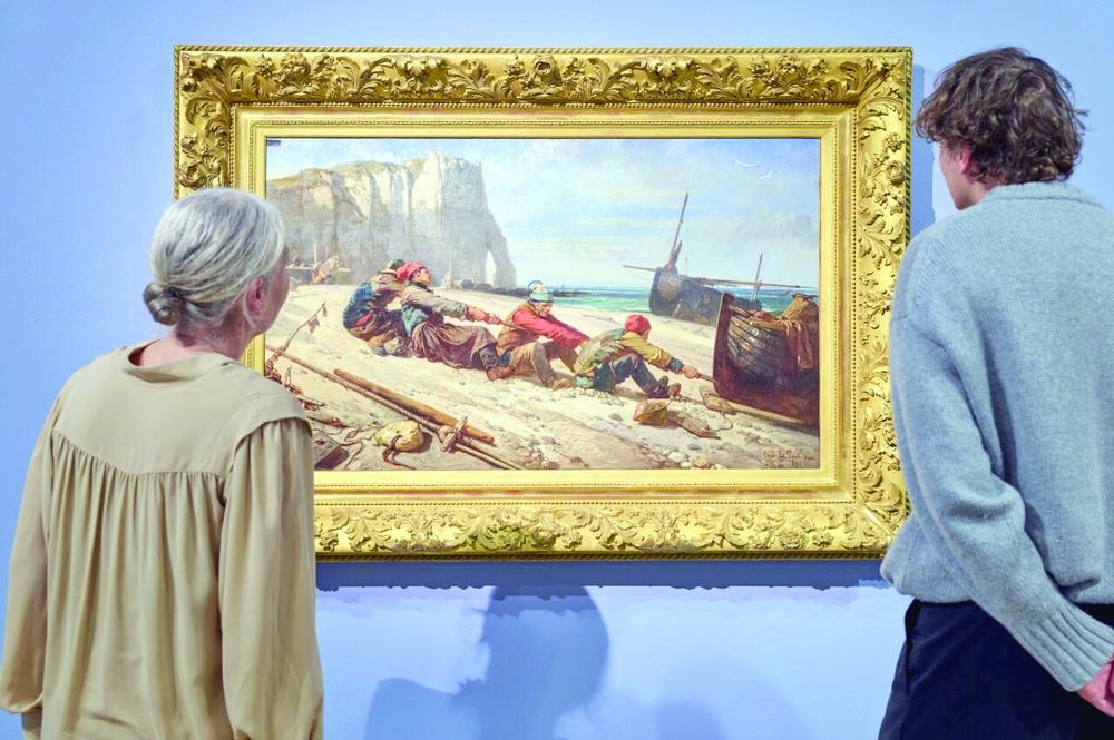 Visitors study Claude Monet’s coastal scene of fishermen hauling a boat at Étretat in the Städel Museum, Frankfurt.