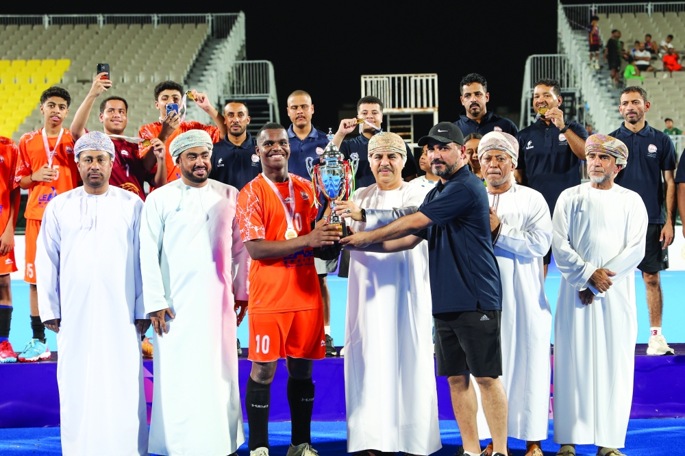Qurayat captain receives the Group 1 champions trophy.
