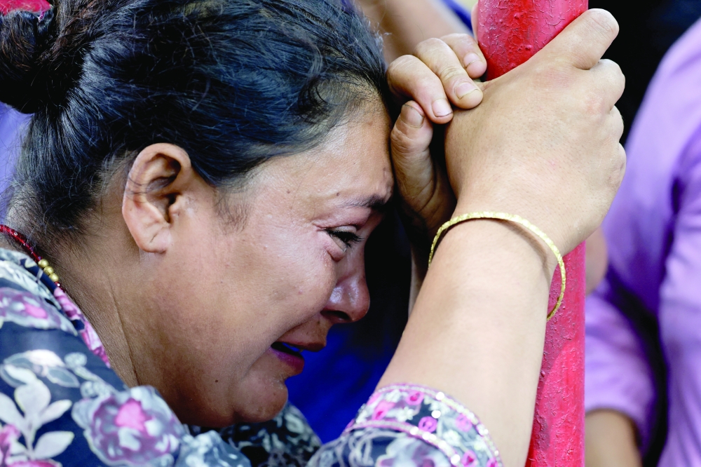 A woman cries as she waits for updates on the whereabouts of her missing family member outside the Maithali Barrack, an army training centre, which serves as a primary base to airlift survivors from Rasuwa at Trishuli in Nuwakot district, Nepal. - Reuters