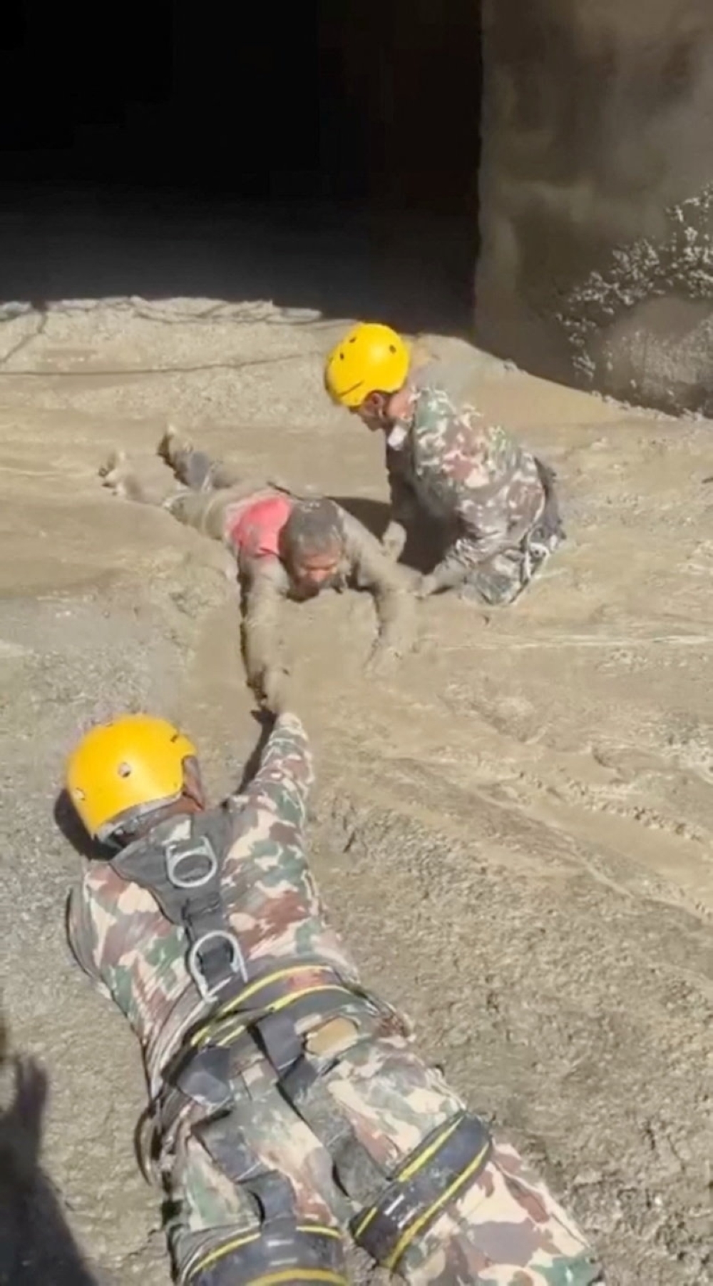 Rescuers evacuate a person from a tunnel of a hydropower project, in the aftermath of flash floods and a mudslide, in Rasuwa, Nepal