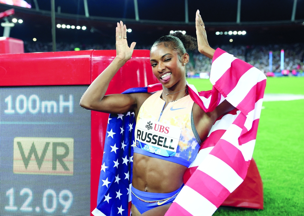 Masai Russell of the U.S. poses with a screen after winning the women's 100m hurdles final and setting a new world record REUTERS
