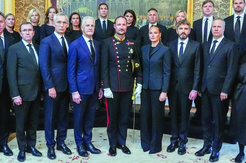 Norway's new King Haakon VIII (C) and Norway's Crown Princess Ingrid Alexandra pose with members of the Norwegian government during an extraordinary cabinet meeting at the Royal Palace in Oslo, Norway. - AFP