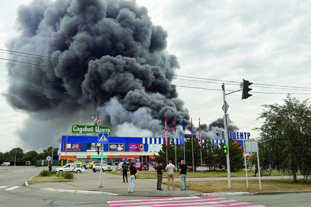 Ukrainian rescue personnel work to extinguish a fire in a damaged shopping mall following an air attack in Zaporizhzhia amid the Russian war in Ukraine. - AFP