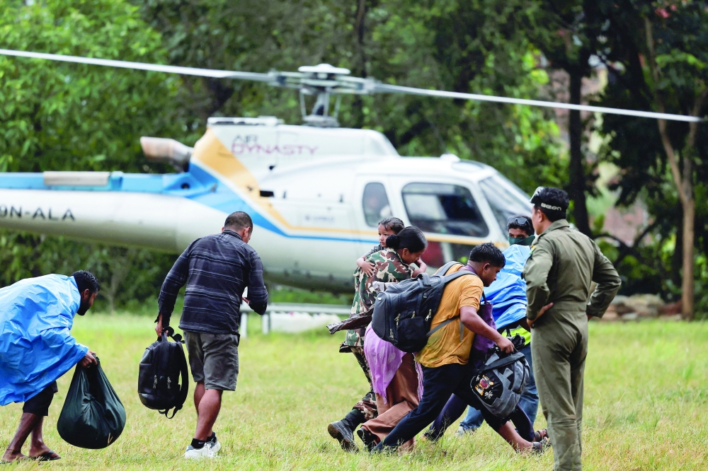 People are evacuated from an affected area following flash floods and mudslides at the Maithali Barrack, an army training centre, in Trishuli, Nuwakot District, Nepal. - Reuters