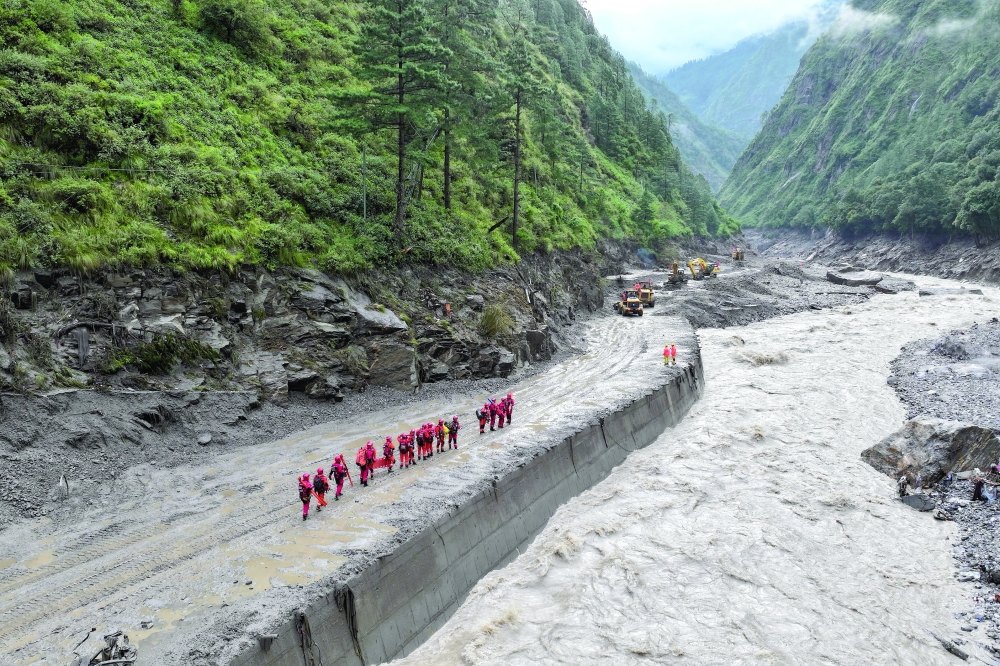 A drone view of firefighters conducting search-and-rescue operations at a damaged road leading to Gyirong Port after a mudslide, in Gyirong County, Shigatse, Tibet Autonomous Region, China. — Reuters