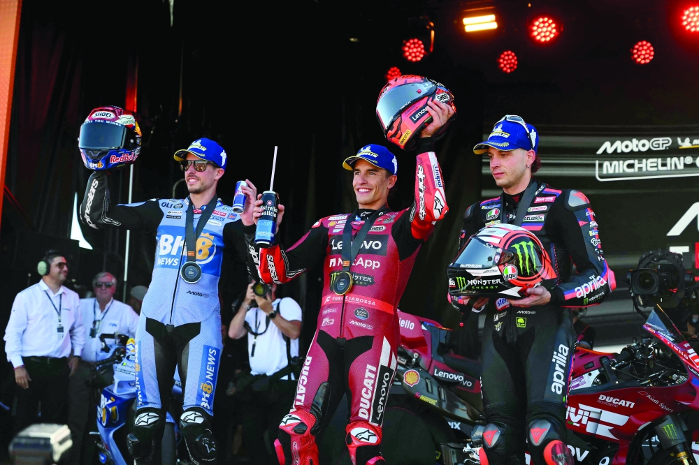 Winner Team Ducati Lenovo Team's Marc Marquez (C) celebrates on the podium with second placed Team Gresini Racing MotoGP's Alex Marquez (L) and third placed Team Aprilia Racing's Marco Bezzecchi after the sprint race of the MotoGP Aragon Grand Prix at the Motorland circuit in Alcaniz, northeastern Spain. — AFP