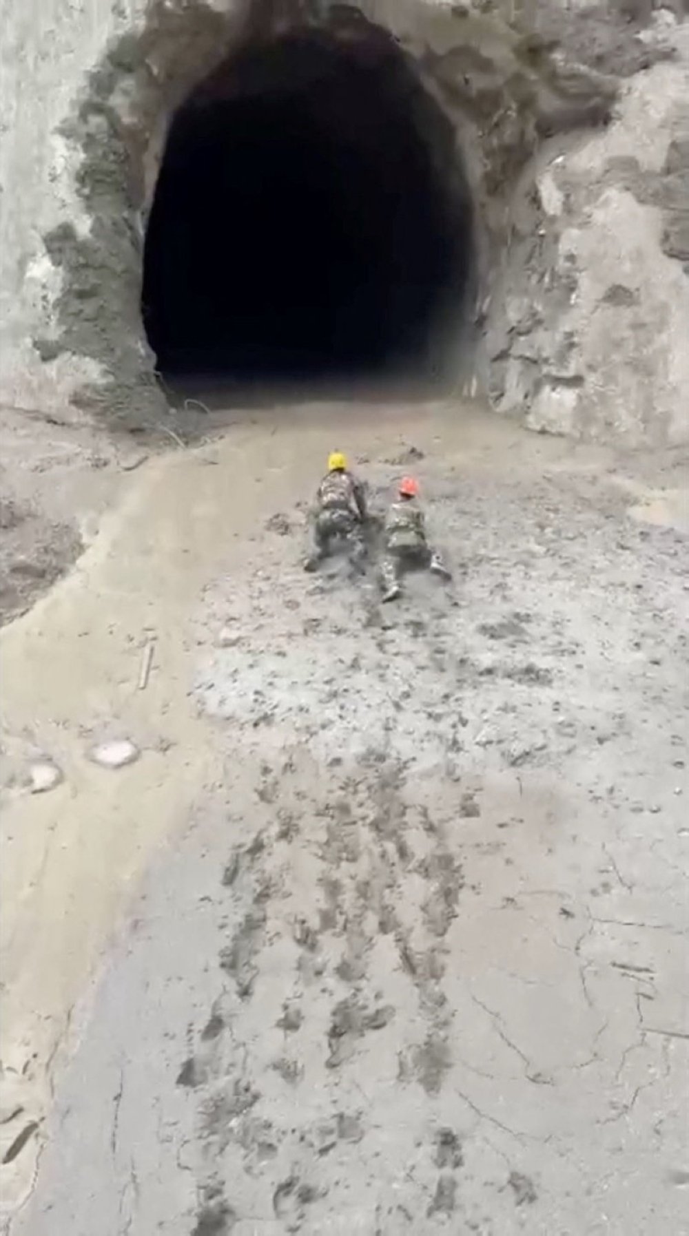 Rescuers make their way to evacuate people from the tunnel of a hydropower project, in the aftermath of flash floods and a mudslide, in Rasuwa, Nepal