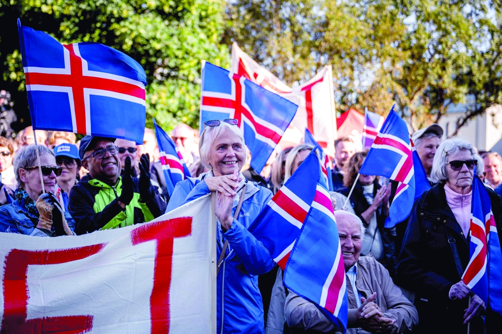 Supporters of the 'No' campaign wave Icelandic flags during a rally in Reykjavik, Iceland. — AFP