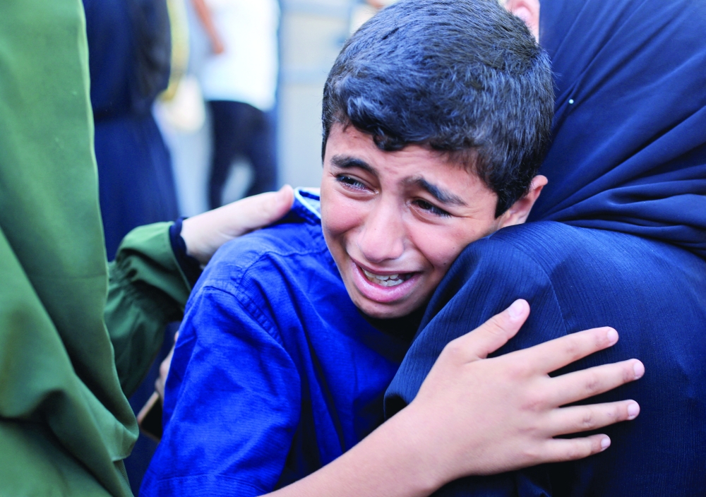 A boy mourns during the funeral of Palestinians who were killed in Israeli strikes in Gaza City. — Reuters