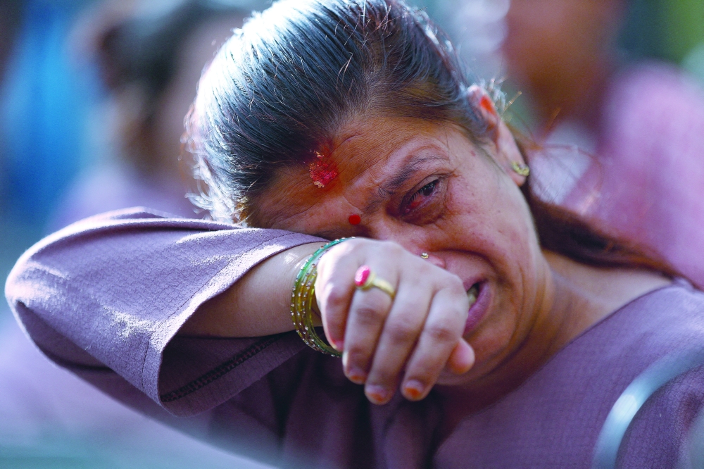 A woman reacts as she arrives at a mortuary to identify bodies of victims who died in flash floods and mudslides in Kathmandu, Nepal, on Sunday. - Reuters