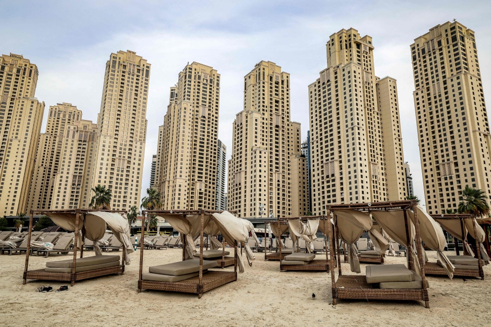 Empty beds are pictured before high-rise buildings along a beach at Jumeirah Beach Residence (JBR) in Dubai 