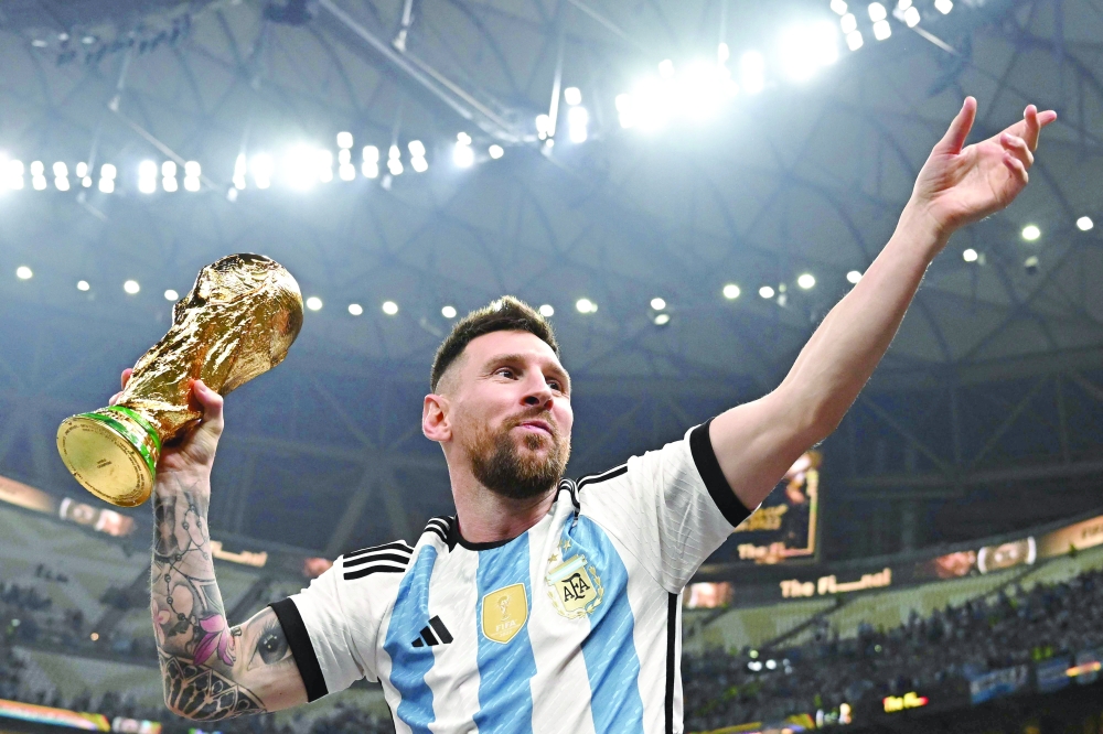 Lionel Messi pose with the FIFA World Cup Trophy