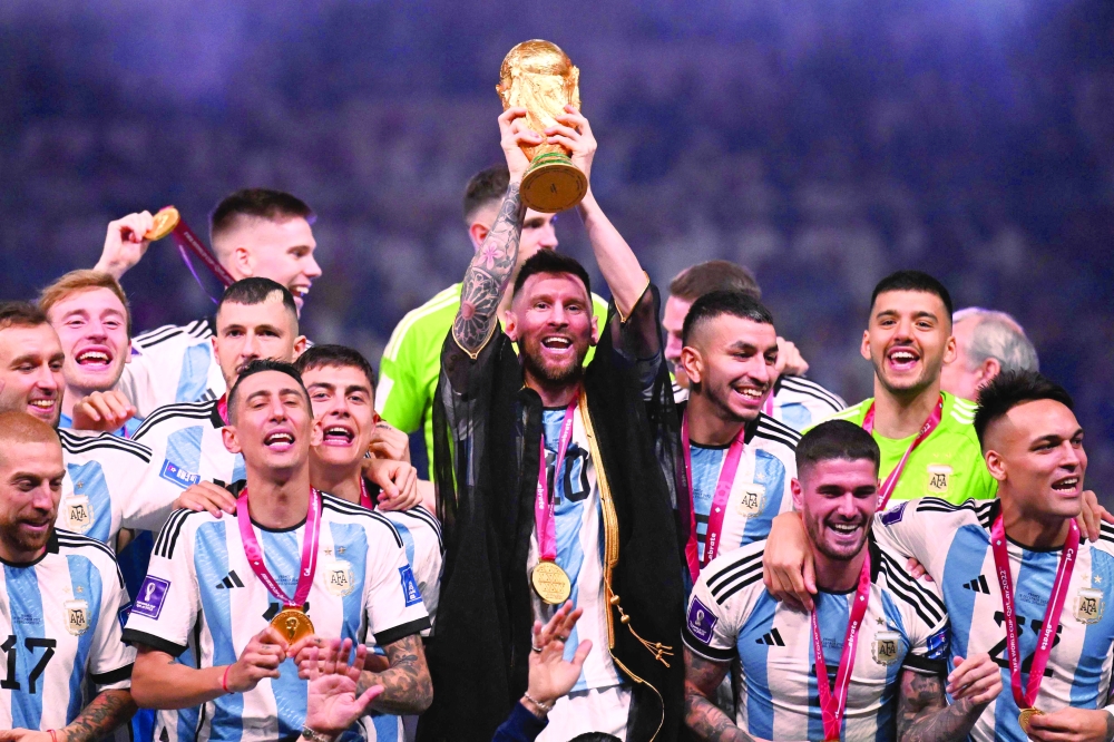 Lionel Messi pose with the FIFA World Cup Trophy