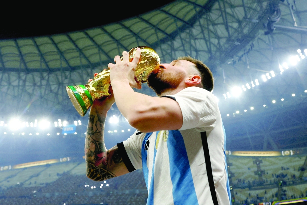 Argentina's Lionel Messi kisses the trophy as he celebrates winning the World Cup 