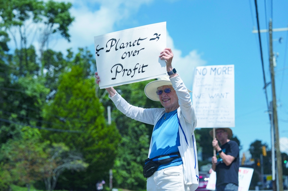 A protestor holds a sign during a "People Over Profits" demonstration ahead of the G20 Finance Ministers and Central Bank Governors’ meeting, North Carolina. — AFP