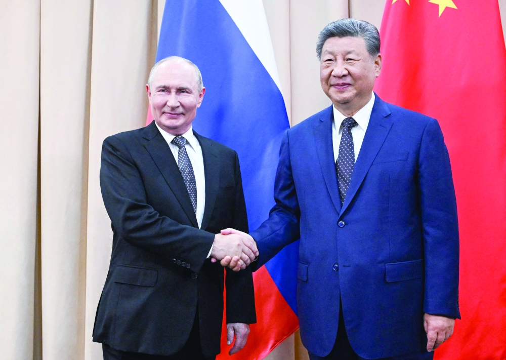 Russia's President Vladimir Putin and China's President Xi Jinping shake hands during a meeting in Bishkek. — AFP