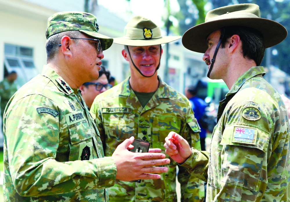 An Indonesian military personnel speaks with members of the Australian Defence Force during the opening ceremony of Super Garuda Shield in Bandung. — Reuters