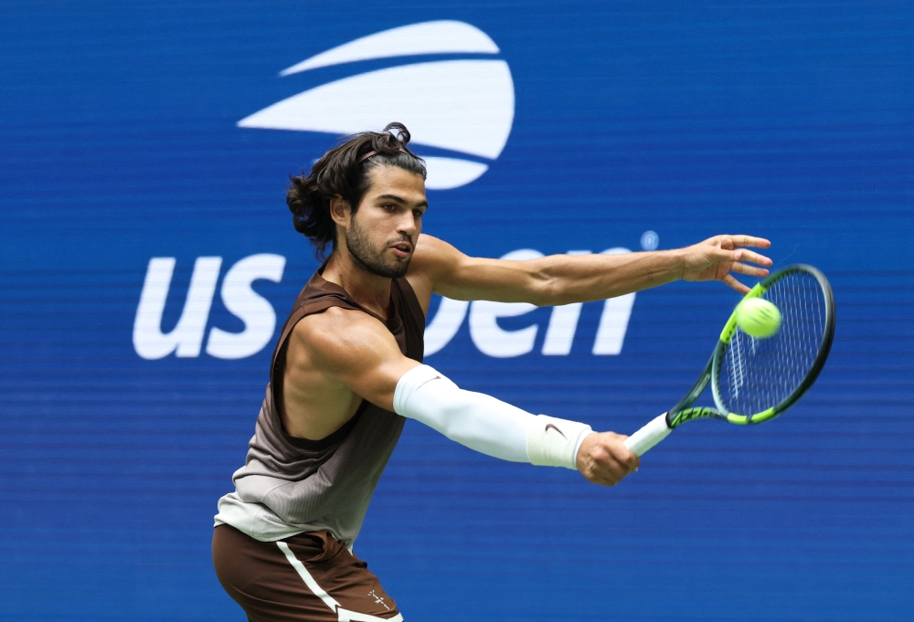 Spain's Carlos Alcaraz hits a return to Russia's Roman Safiullin during their men's singles first round tennis match on day two of the US Open tennis tournament at the USTA Billie Jean King National Tennis Center in New York City on August 31, 2026. (Photo by TIMOTHY A. CLARY / AFP)
