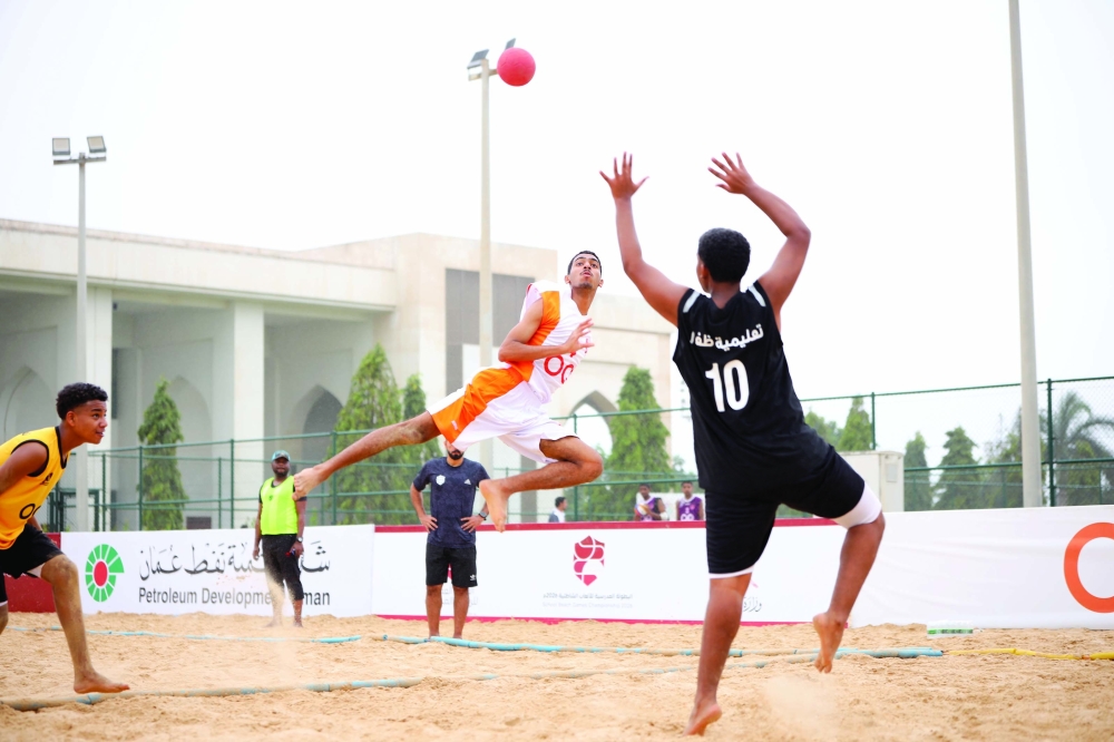 School teams compete fiercely in the beach handball semifinals.