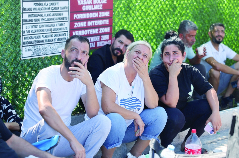 Relatives view a helicopter flying outside Kyrenia port, after a passenger boat capsized. — Reuters 