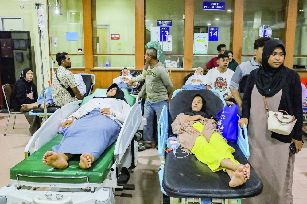 Students rest while receiving treatment for food poisoning at the regional general hospital after eating government-sponsored free school meals in Sidoarjo, East Java province, Indonesia. - Reuters 