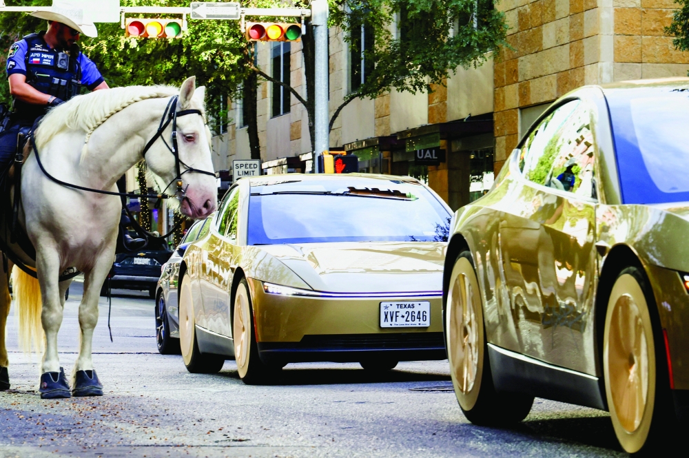 Mounted police patrols as gold-colored Tesla Cybercabs arrive for an event in downtown Austin, Texas.  — Reuters