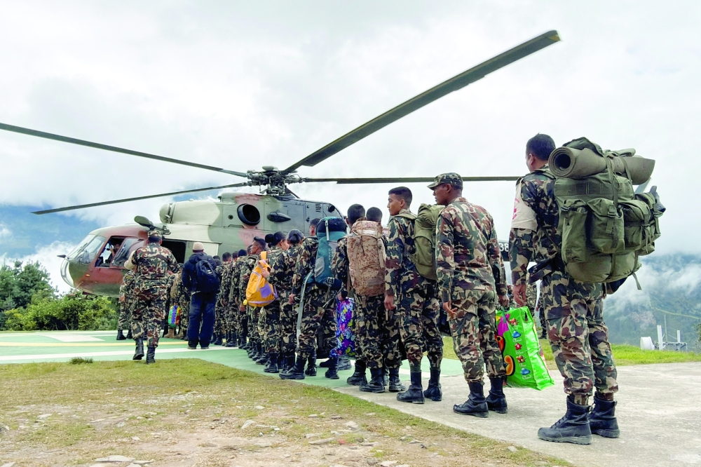 Members of the Nepal Army board a helicopter carrying relief supplies to a flood-affected area in Dhunche, the headquarters of Rasuwa district, Nepal. — Reuters