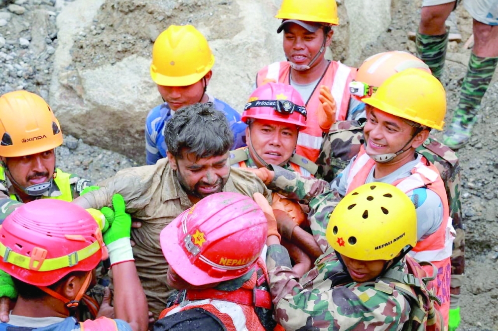 Survivor Sanjay Sah is carried by members of a search and rescue team after they rescued alive two people who had been trapped inside a tunnel at the Upper Trishuli-3A Hydropower Project following devastating floods and mudslides that struck the Bhotekoshi River in Rasuwa, Nepal. — Reuters