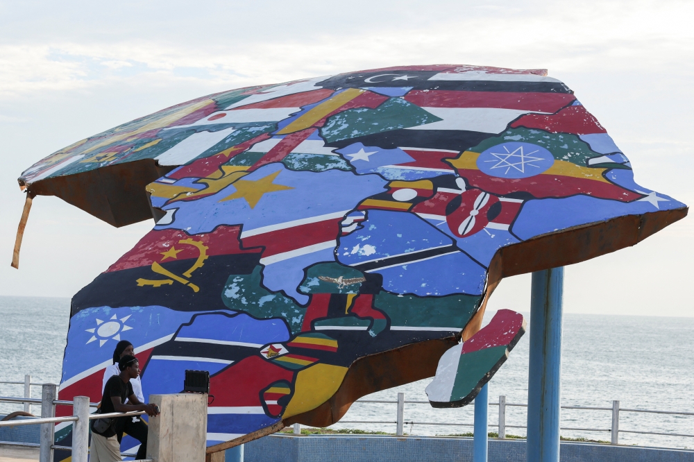 People stand beside a sculpture of the African continent, painted with the flags of African nations, at the Place du Souvenir Africain in Dakar, Senegal, September 3, 2026. REUTERS/Misper Apawu